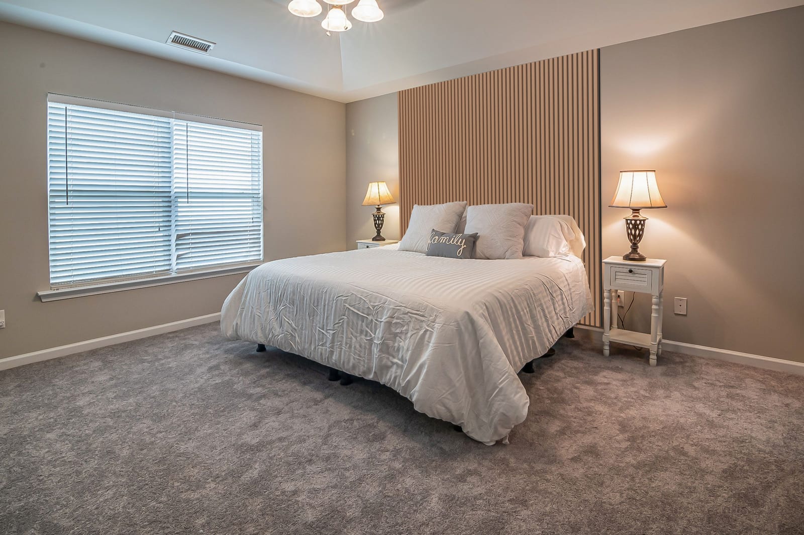 Walnut slatted wall from floor to ceiling behind a double bed, with no frames