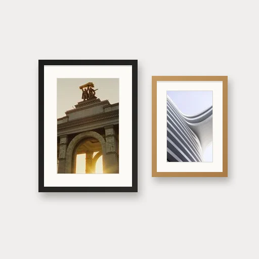 Two framed prints, one in a black frame and one in oak