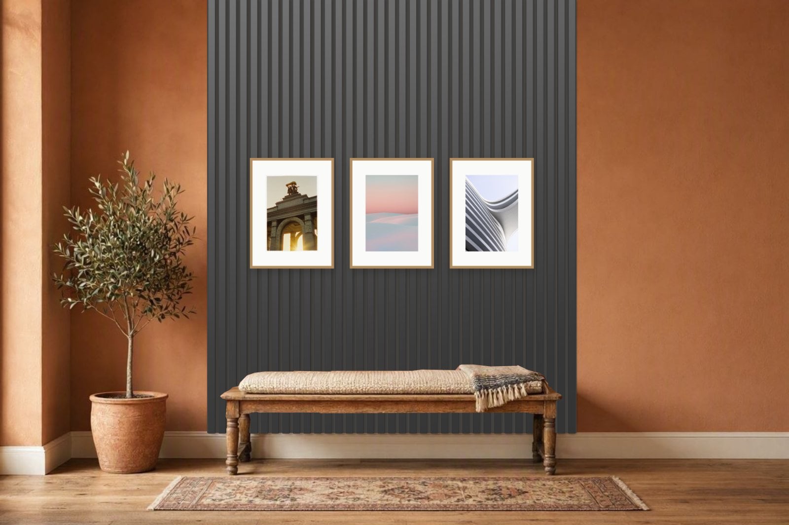 Wall panel visualizer result: black acoustic slats from floor to ceiling behind a wooden bench in a terracotta hallway, with three oak-framed prints